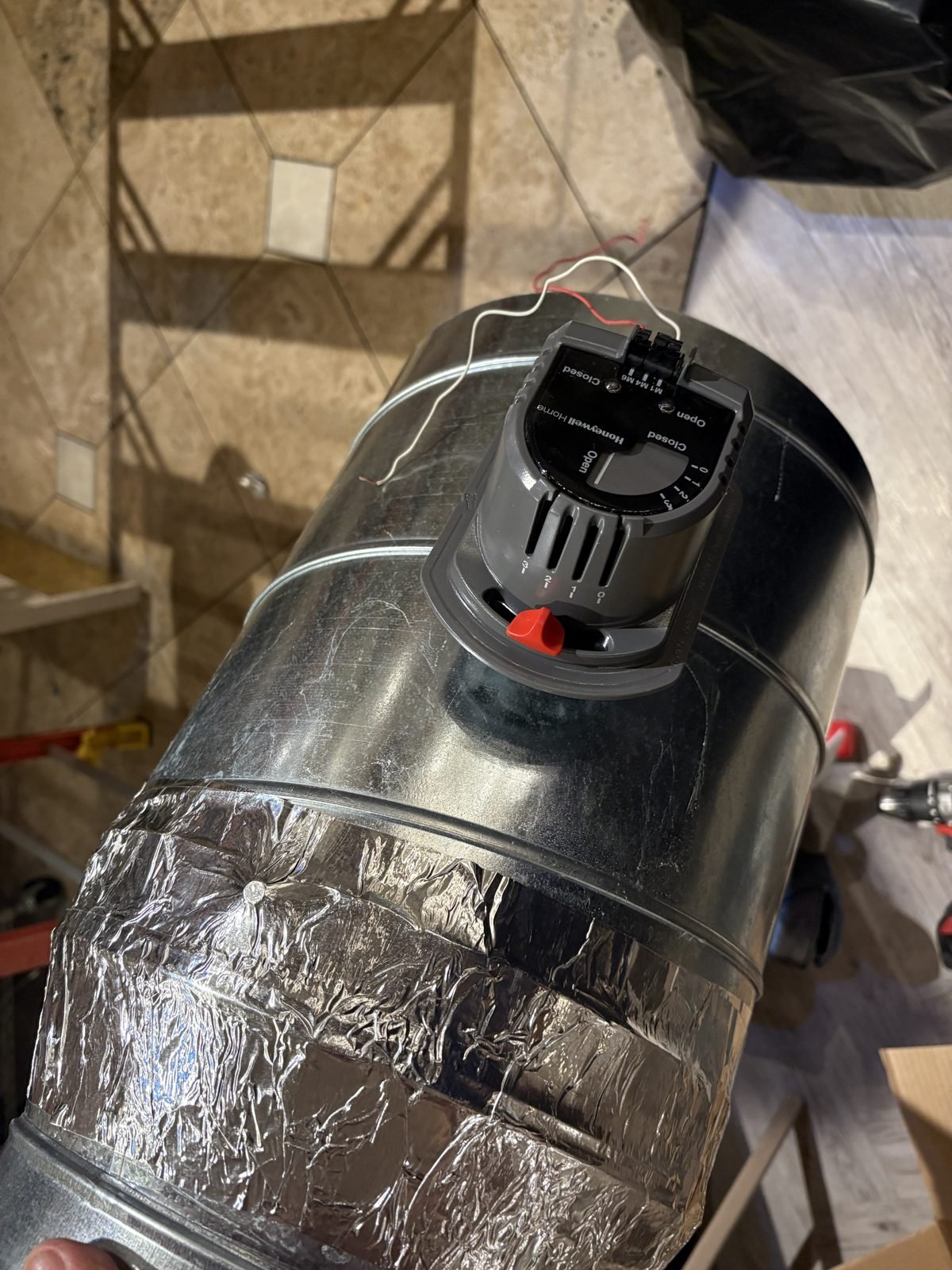 A mechanical zone damper. The office gets air when the office needs it.