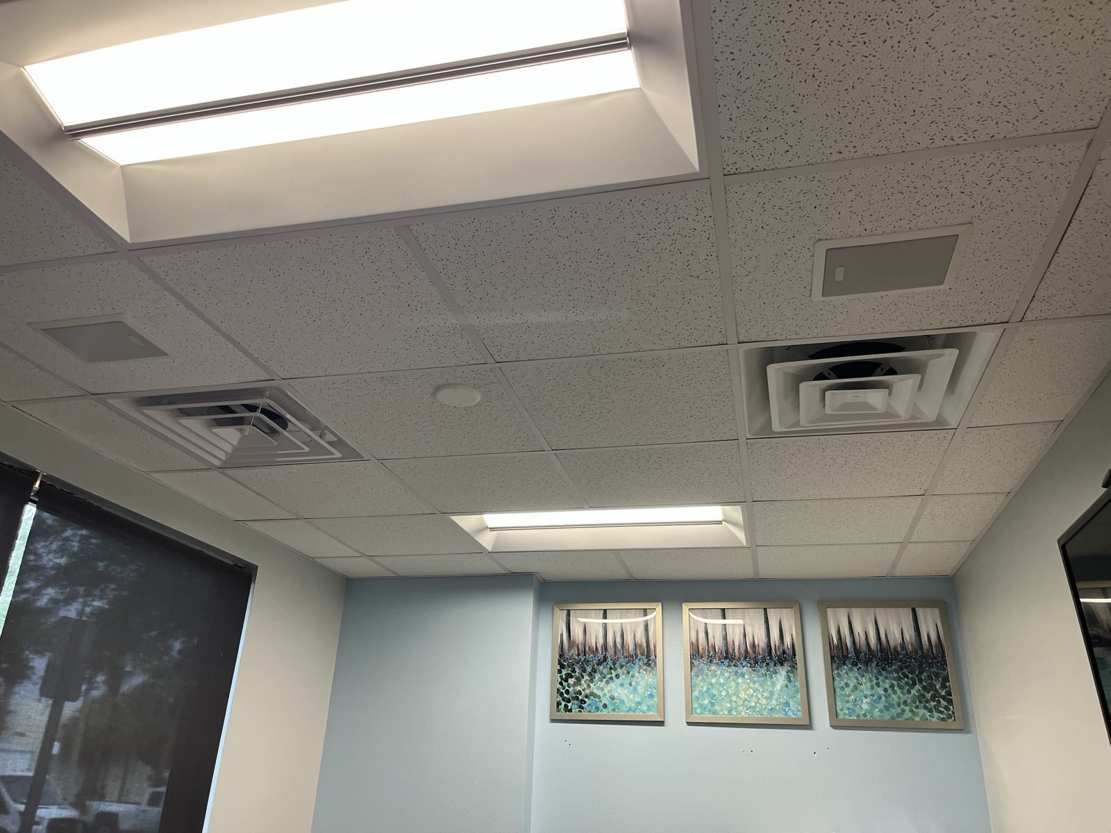 An office that was short on supplies. One room cooked in the afternoon sun. We added a diffuser & moved the other so they sit even in the grid. Looks like it was always there. Now it stays cool.