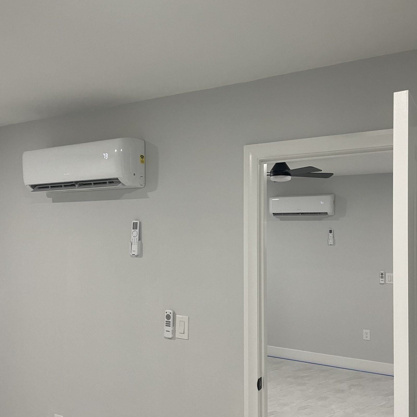 Two heads, one outdoor unit, multi zone. Remotes mounted by the switch so nobody loses them.